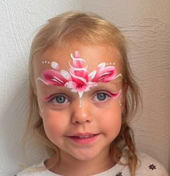 Meisje met roze bloemenkroon-schmink op het voorhoofd en glittersteentje tussen de wenkbrauwen