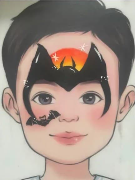 Jongen met Batman-schmink: zwart vleermuisembleem met oranje zonsondergang op het voorhoofd