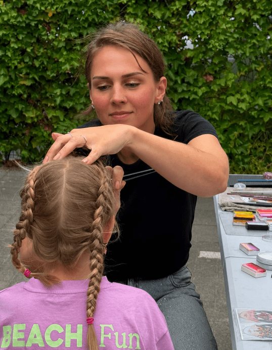 Nadine schminkt een kind met huidvriendelijke schmink, schminkspullen op tafel